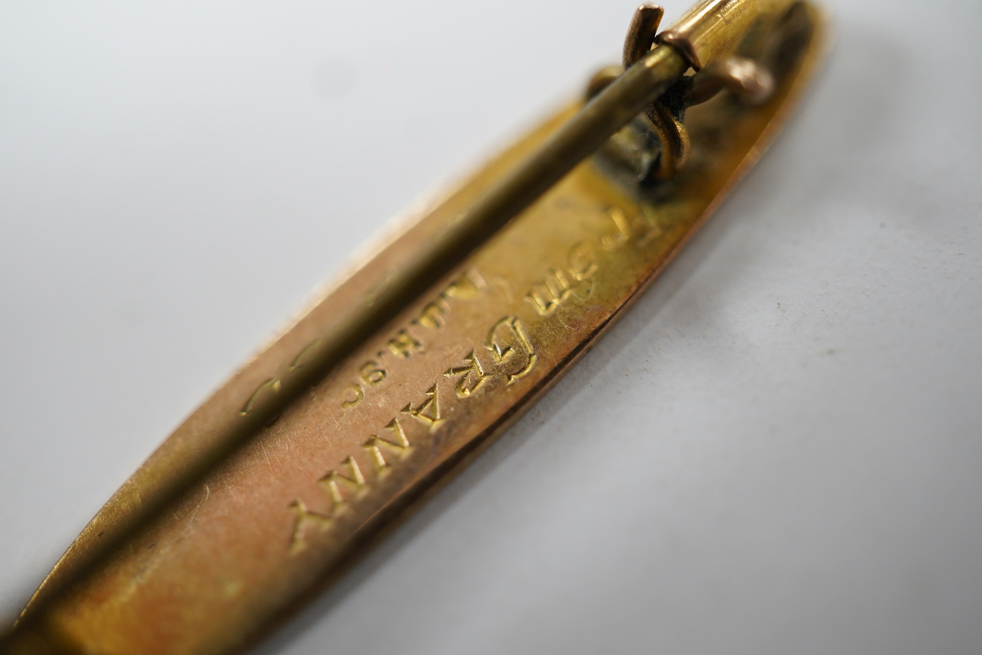 A '9ct and silver' hunting horn bar brooch, 62mm, together with a 1930's yellow metal brooch, with engraved inscription. Condition - fair